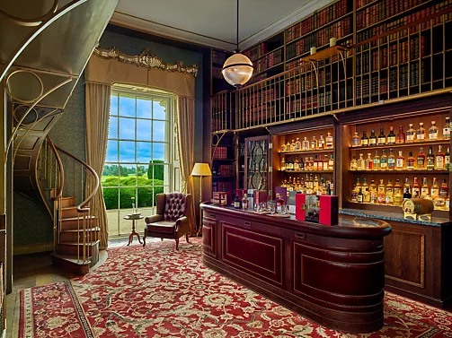 A library room at Carton House, Co. Kildare, with a spiral staircase and a whiskey bar